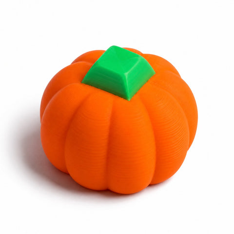 Orange 3D printed pumpkin fidget with a green keycap on top, on a white background